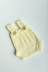 Various colors and types of cotton clothing, knitted newborn clothes and newborn hats on a white background.