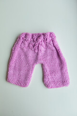 Various colors and types of cotton clothing, knitted newborn clothes and newborn hats on a white background.