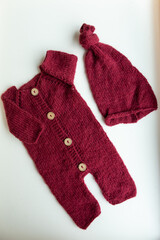 Various colors and types of cotton clothing, knitted newborn clothes and newborn hats on a white background.