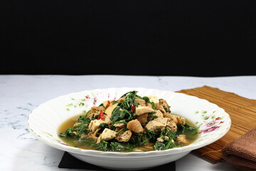 Fried and stirred spicy fresh Paco Fern with tofu, chilly and basil on the plate. Famous hot and spicy vegetarian menu in Asia restaurant. 