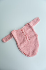 Various colors and types of cotton clothing, knitted newborn clothes and newborn hats on a white background.
