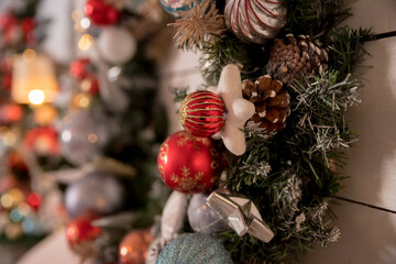 Traditional Christmas wreath made of fir branches, cones and Christmas toys on the door.Christmas decoration fir wreath with balls.Winter holiday's decoration.Selective focus