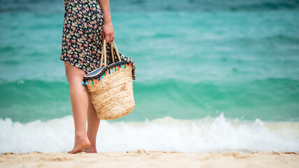 Woman walking on Summer tropical beach white sand blue sea summertime on sunny day. Sea coast beach scenery foamy wave on the beach waves of blue sea tropical ocean sand