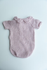 Various colors and types of cotton clothing, knitted newborn clothes and newborn hats on a white background.
