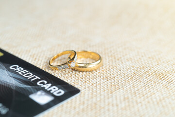 Obraz na płótnie Canvas Gold wedding rings with credit cards, pay the cost by credit card.
