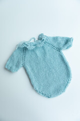 Various colors and types of cotton clothing, knitted newborn clothes and newborn hats on a white background.