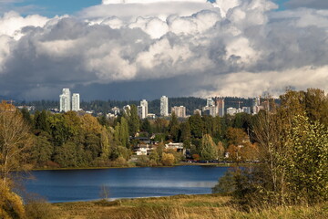 Fototapeta premium Residential area near Deer Lake Park in Burnaby, the construction of three skyscrapers in the area against the Stormy Cloudy Sky
