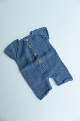 Various colors and types of cotton clothing, knitted newborn clothes and newborn hats on a white background.