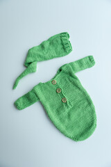 Various colors and types of cotton clothing, knitted newborn clothes and newborn hats on a white background.