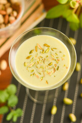 Pista Badam milk shake or Almond Pista milk prepared with almonds, pista and milk Kerala India. Kheer or North Indian traditional health drink Flavoured pistachio milk or badam lassi with dry fruits.