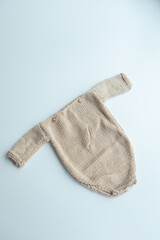 Various colors and types of cotton clothing, knitted newborn clothes and newborn hats on a white background.