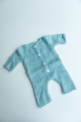 Various colors and types of cotton clothing, knitted newborn clothes and newborn hats on a white background.