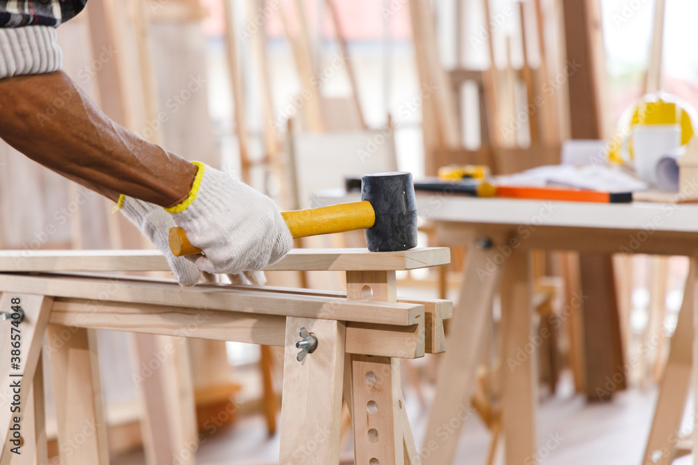 Wall mural carpenter using mallet in woodwork.