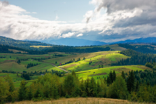 beautiful scenery of mountainous countryside. clouds above the hills rolling in to the distant valley. carpathian landscape in dappled light. dramatic weather conditions.