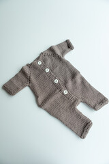 Various colors and types of cotton clothing, knitted newborn clothes and newborn hats on a white background.