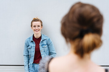 Friendly young woman smiling in greeting