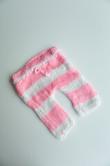 Various colors and types of cotton clothing, knitted newborn clothes and newborn hats on a white background.