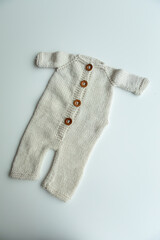 Various colors and types of cotton clothing, knitted newborn clothes and newborn hats on a white background.