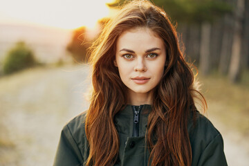 Naklejka premium pretty woman in jacket looking forward cropped view nature travel background