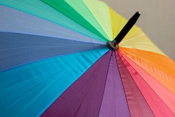 A multi-colored umbrella with stripes in rainbow colors, a symbol of the LGBT flag.