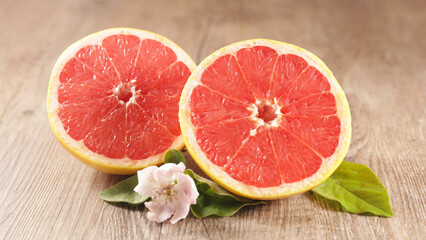 Fototapeta na wymiar red grapefruit and leaf on wood background
