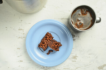 Chocolate bar on a plate with coffee