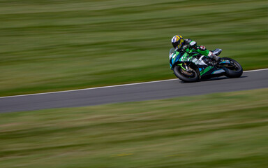A panning shot of a racing bike cornering on a track.