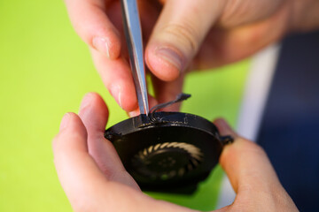 man cleans a laptop with a special tool from dust. Repair and maintenance of laptops and PCs Advertising services for the repair of electronics and devices.