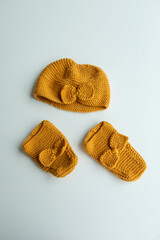 Various colors and types of cotton clothing, knitted newborn clothes and newborn hats on a white background.
