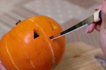 the process of making a Halloween pumpkin. cutting nose. horror theme and Hallowe'en. 