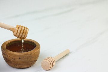 Madu or Honey, one of healthy food, put in wooden bowl with wooden honey dipper. Selective focus,...