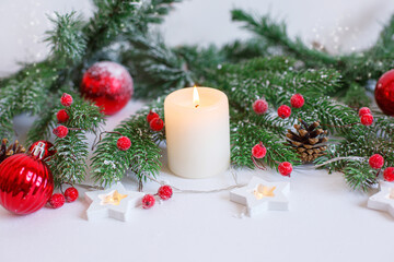 Christmas background, red Christmas toys , beads and a burning candle. Merry Christmas greeting card