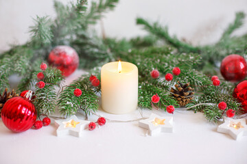 Christmas background, red Christmas toys , beads and a burning candle. Merry Christmas greeting card