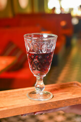 Holding wine glass inside on a wooden board. Eating out in restaurant concept.