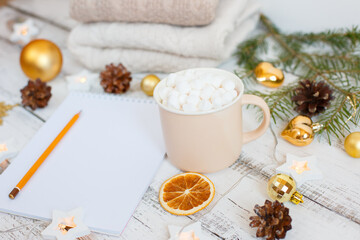 Fototapeta na wymiar Christmas background, Notepad with pencil, coffee mug and marshmallows , Golden Christmas tree toys . Letter To Santa Claus. Merry Christmas greeting card
