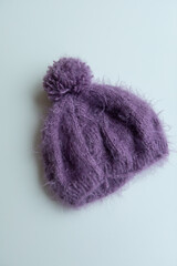 Various colors and types of cotton clothing, knitted newborn clothes and newborn hats on a white background.