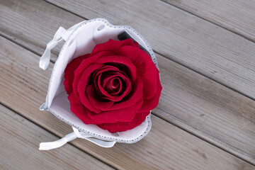 Red rose flower and N95 mask on wooden board