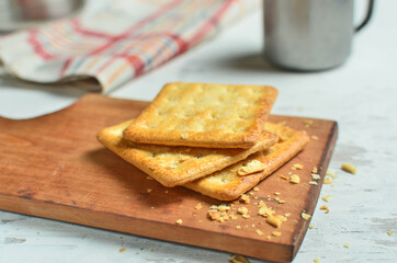 Cracker and coffee on the wooden chopping board on the table