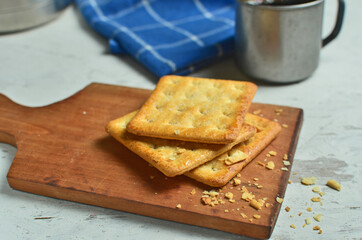 Cracker and coffee on the wooden chopping board on the table