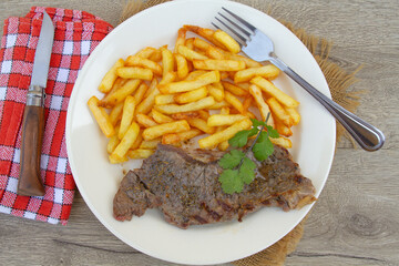 entrecôte de boeuf et frites dans une assiette