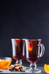 Mulled wine on a slate board. Two glasses of hot mulled wine and ingredients. Christmas hot drink with wine and honey