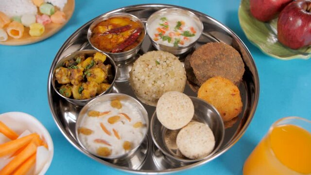 Closeup shot of beautifully plated Navratri thali/platter rotating on a turntable. High angle shot of traditional North Indian food served during the religious Upwas/fasting days during Navratri