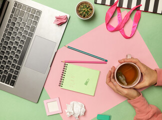 Woman working with modern laptop, took a break to drink a cup of tea