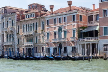 View of the Grand Canal with gondolas and colorful facades of old medieval houses in Venice, Italy.