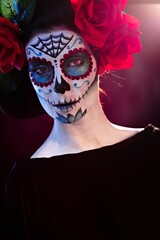 Portrait of scary woman in santa muerte makeup looking at camera.