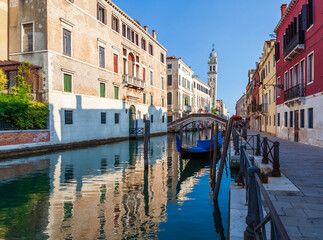 Fototapeta na wymiar Venice cityscape, narrow water canal, campanile church on background and traditional buildings. Italy.