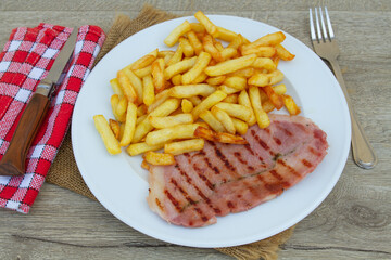 tranche de jambon grillé et frites dans une assiette