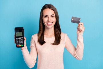 Close-up portrait of her she nice attractive pretty cheerful cheery brown-haired girl holding in hands pos reader bank card customer isolated bright vivid shine vibrant blue color background