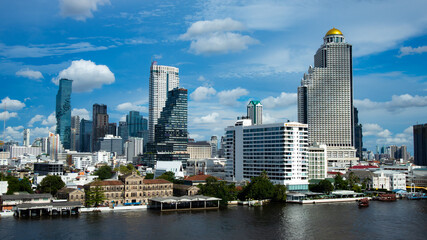Fototapeta na wymiar Bangkok thailand 14/9/20 Jaopraya river side view, A daytime sky with white clouds in the city, focus on the buildings.