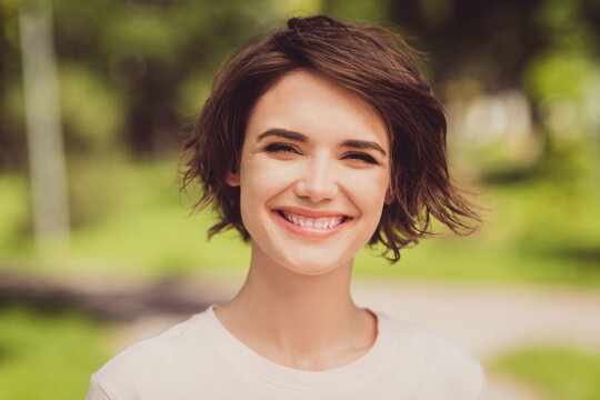 Closeup photo of nice adorable cute glad young girl lady toothy smile look direct camera spend free time urban park fresh air sunny weather good mood news green summer spring place outside
